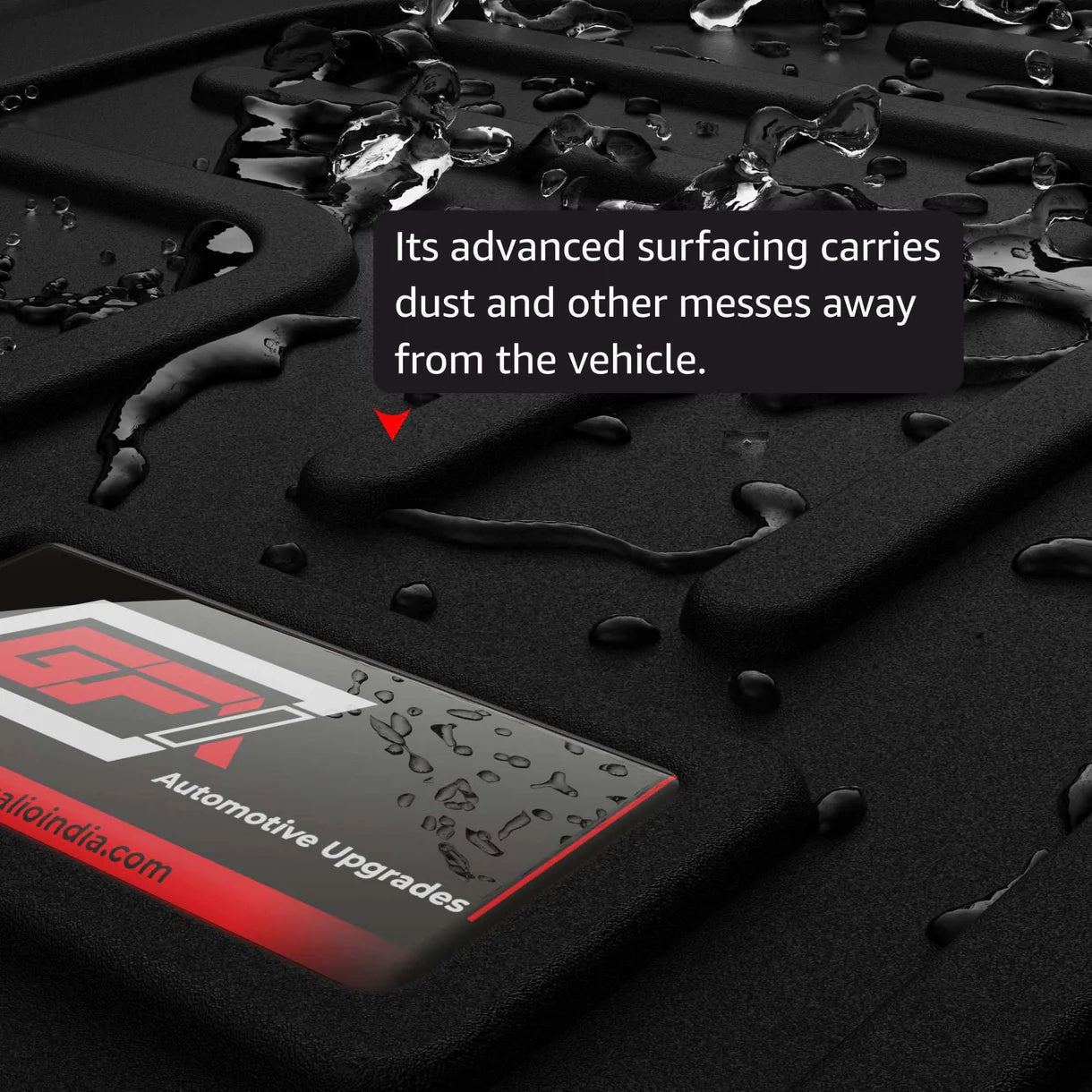 Close-up of a black GFX precision-fit Mahindra XUV700 (6 Seater) car floor mat with water droplets. A label reads “GFX.” Text overlay: “Advanced surfacing carries dust and messes away from the vehicle.” Includes matching GFX trunk mat.
