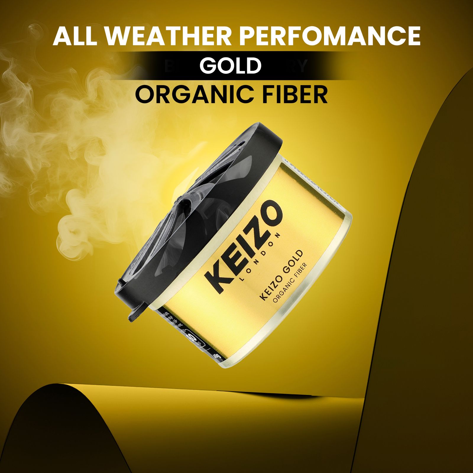 A yellow can of Keizo London Gold 40g Car Perfume with a black lid rests against a yellow backdrop, steam wafting up. ALL WEATHER PERFORMANCE GOLD ORGANIC FIBER text above suggests the luxury scent of this Keizo car perfume.