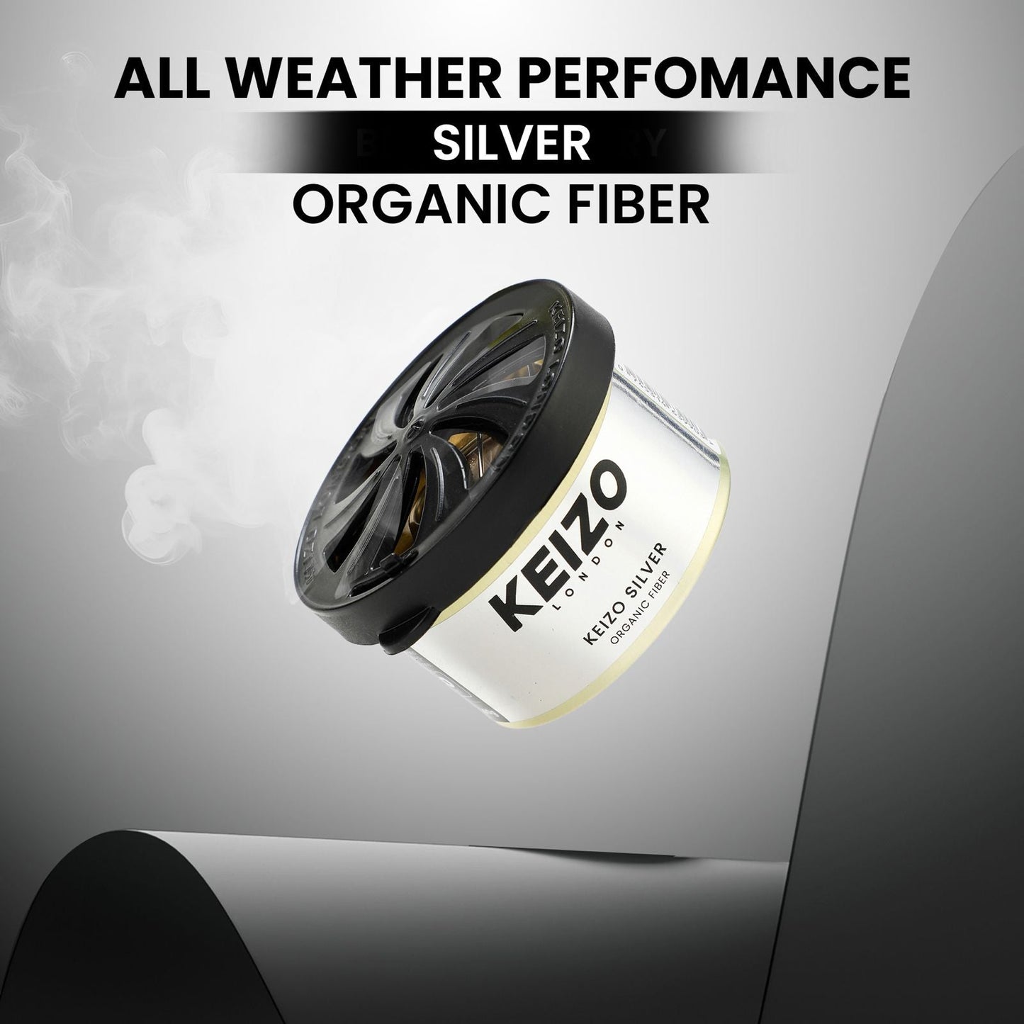 A Keizo London Silver 40g Car Perfume floats with smoke curling up, highlighted by bold text: All Weather Performance, Silver, Organic Fiber—showcasing sleek modern freshness for an elegant drive.