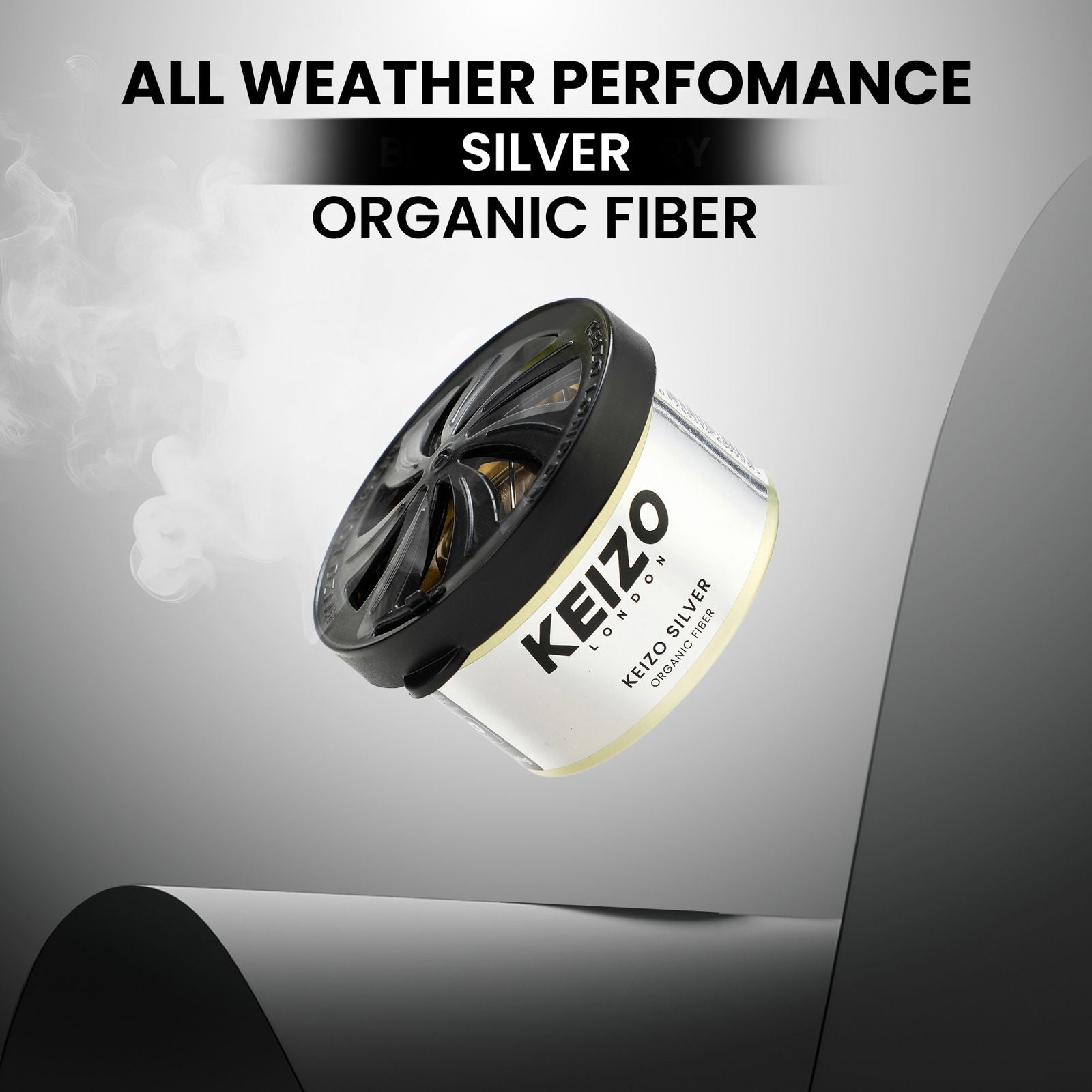 A Keizo London Silver 40g Car Perfume floats with smoke curling up, highlighted by bold text: All Weather Performance, Silver, Organic Fiber—showcasing sleek modern freshness for an elegant drive.