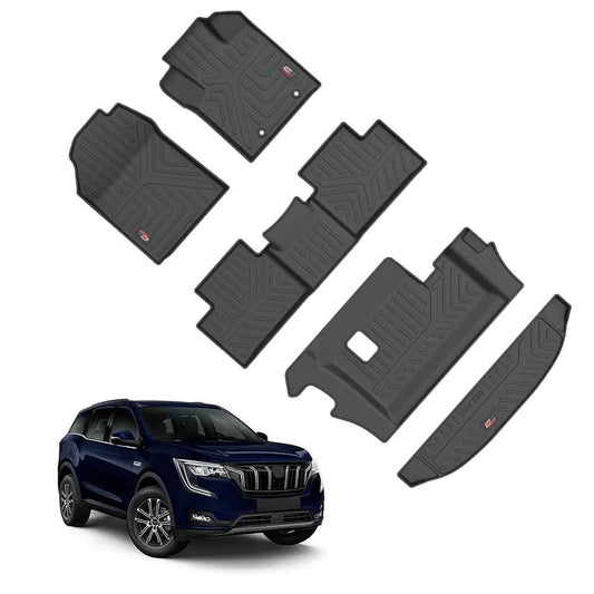A set of GFX Life Long Car Floor Mats and a GFX Trunk Mat for the Mahindra XUV700 (6 Seater) is displayed above a dark blue SUV, offering precision fit as essential accessories by GFX for the XUV700’s interior.